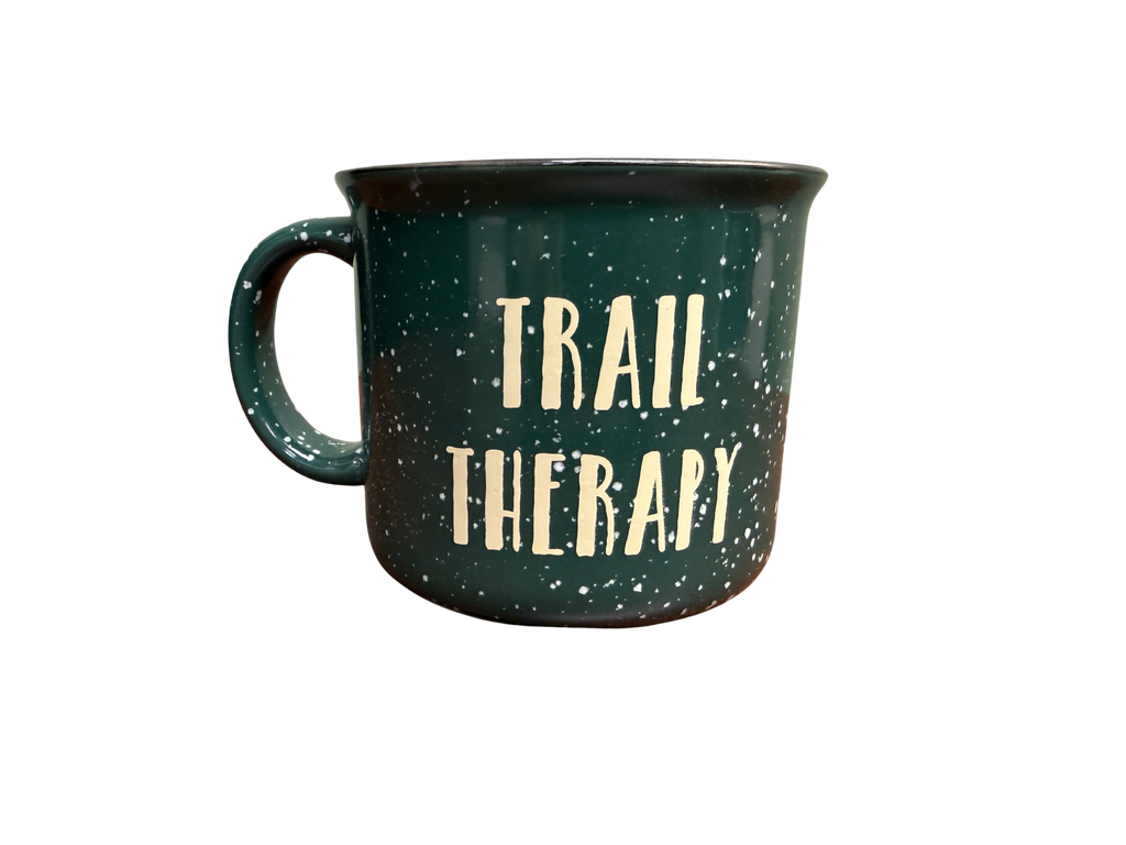 Green mug with 'Trail Therapy' text on a white background